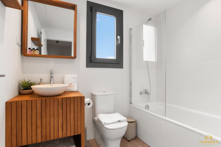Badkamer met bad en eikenhouten wastafelmeubel