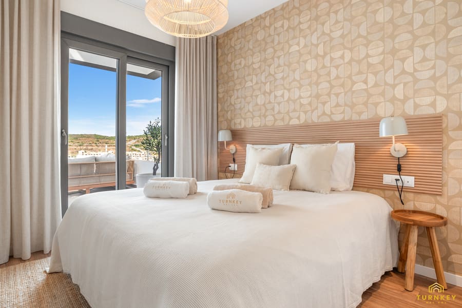 Slaapkamer een met kingsize bed en balkondeuren