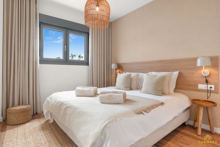 Slaapkamer twee met kingsize bed en rotan hanglamp